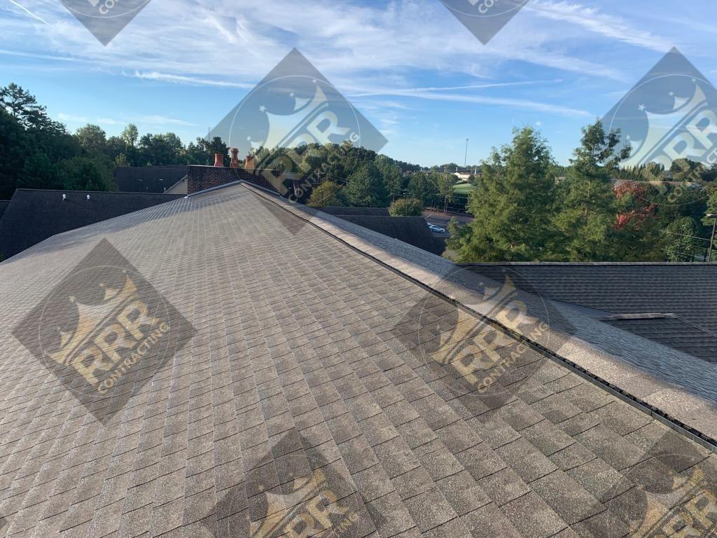 Close-up of a freshly installed asphalt shingle roof against a blue sky
